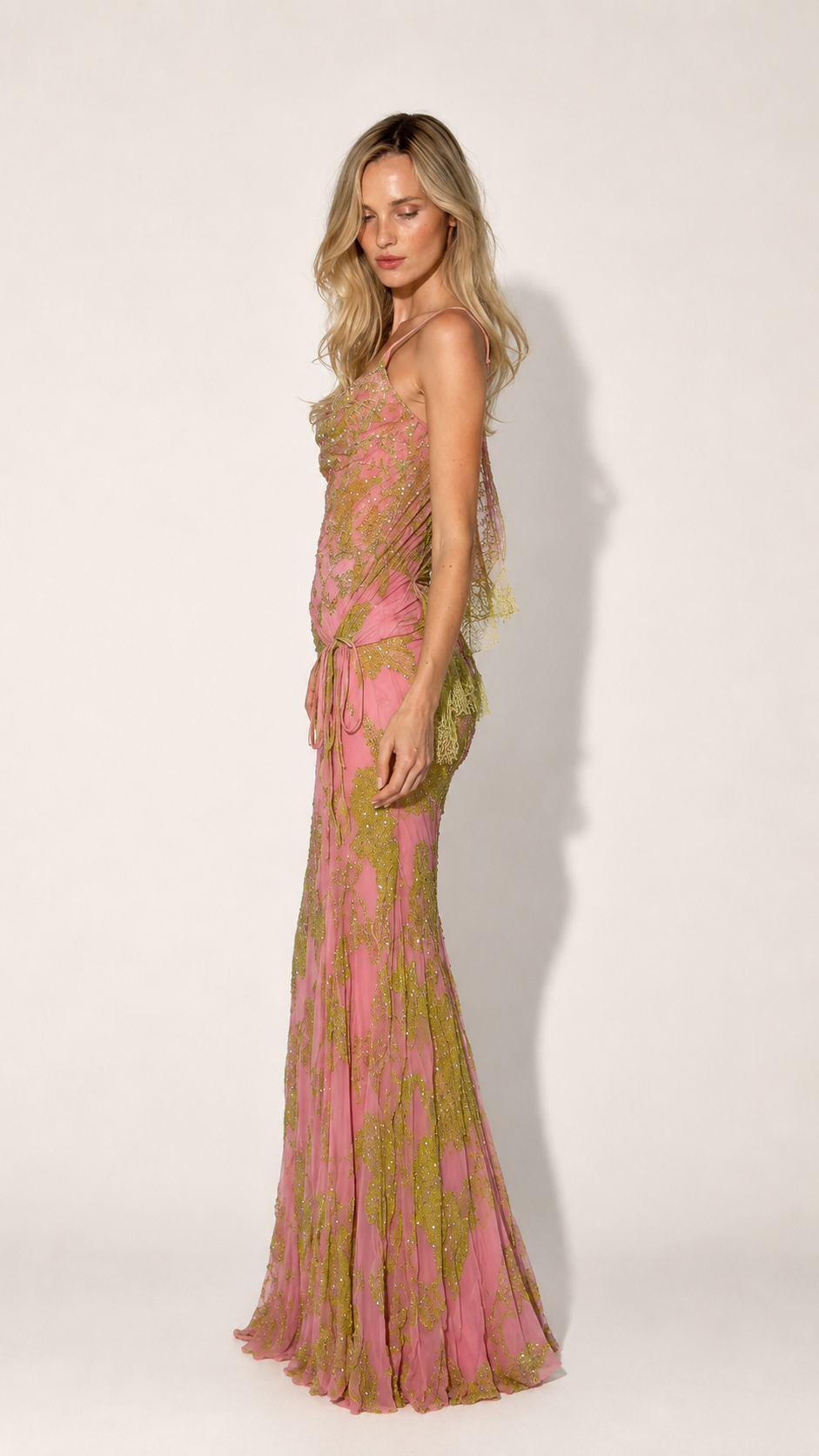 Side view of pink asymmetrical evening gown with cowl neckline and floor-length slim silhouette